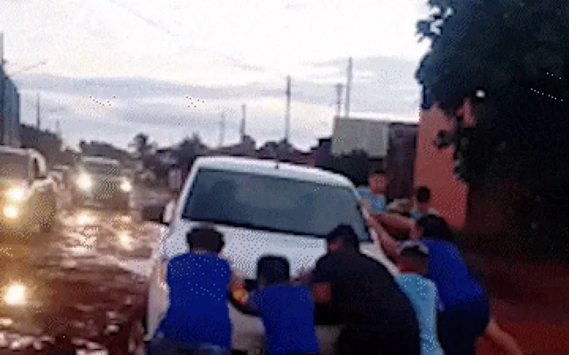 Crianças ajudam motorista a tirar carro de atoleiro em Campo Grande